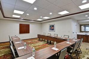 A conference room with a long table, chairs, water bottles, and a framed picture on the wall. - Hampton Inn Albany-Wolf Road (Airport) (Albany)