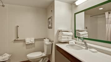 A modern bathroom with a toilet, a sink, and a shower area.