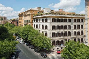 Stunning building with a classical facade, surrounded by lush greenery and urban charm.