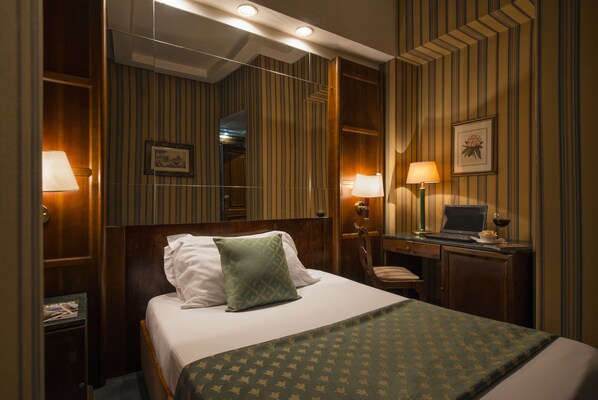 Relax in a cozy retreat with a comfortable bed, a desk for work, and a warm atmosphere.