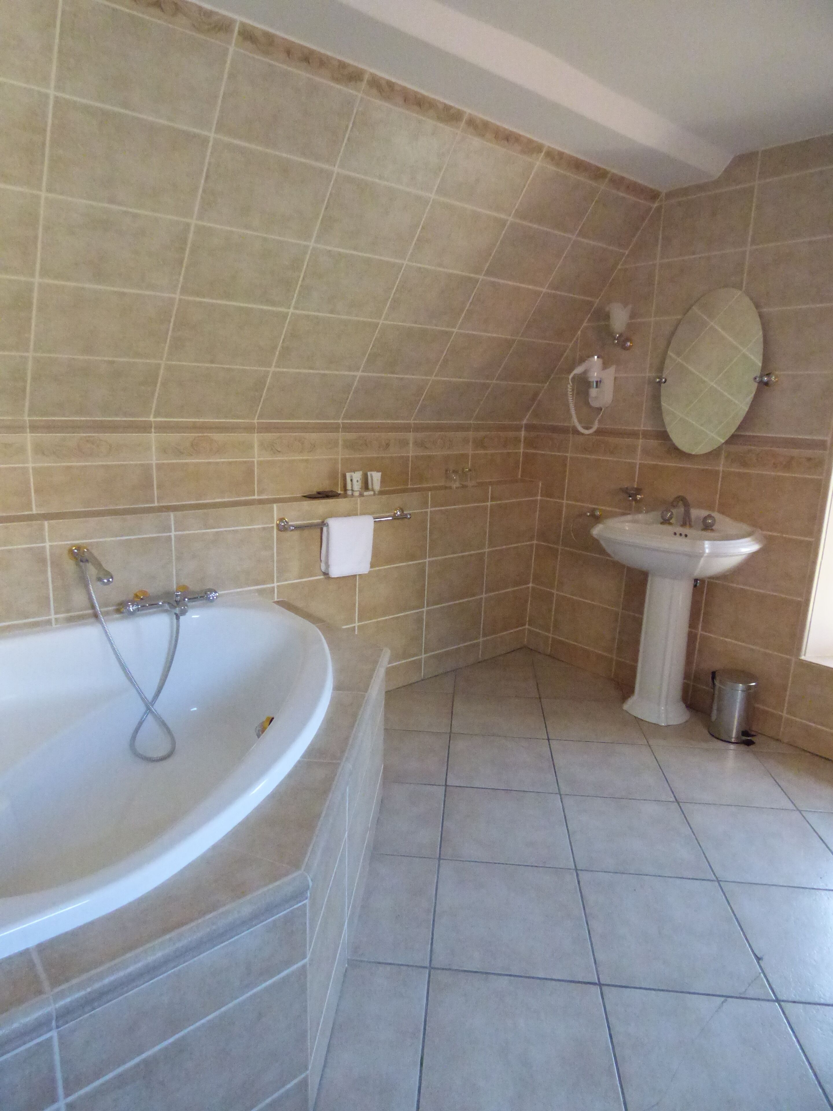 Une salle de bain avec une baignoire, un lavabo et un miroir.