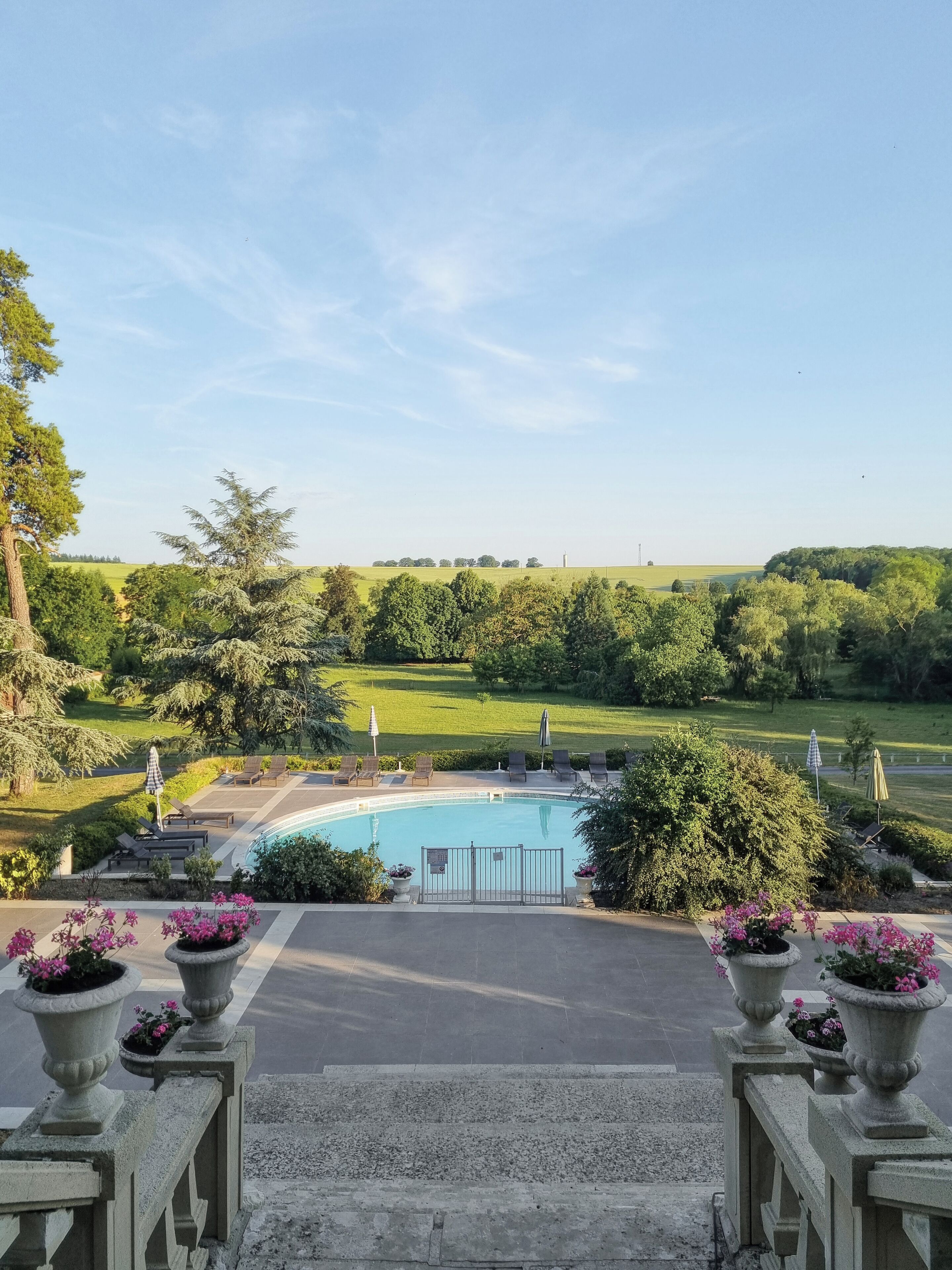 Zona de piscina con vistas a un campo de golf y árboles.