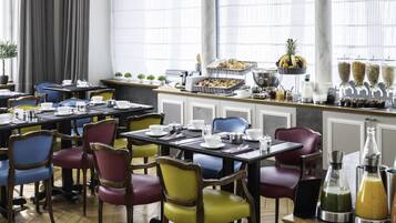 A dining area with multiple tables and chairs, a buffet with various food items, and a bar with beverages.