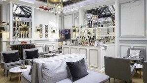 A modern interior with a bar area, seating arrangements, and decorative elements. - Hôtel Bradford Elysées – Astotel (Paris)
