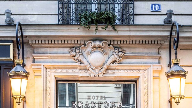 A hotel entrance with ornate decorations, a sign reading "HOTEL BRADFORD," and a number "10" above the entrance. - Hôtel Bradford Elysées – Astotel (Paris)