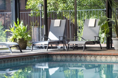 Una piscina techada, sillones reclinables de piscina