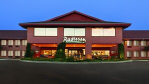 A Radisson hotel with a brick facade, large windows, and a prominent sign. - Radisson Hotel Colorado Springs Airport (Colorado Springs)