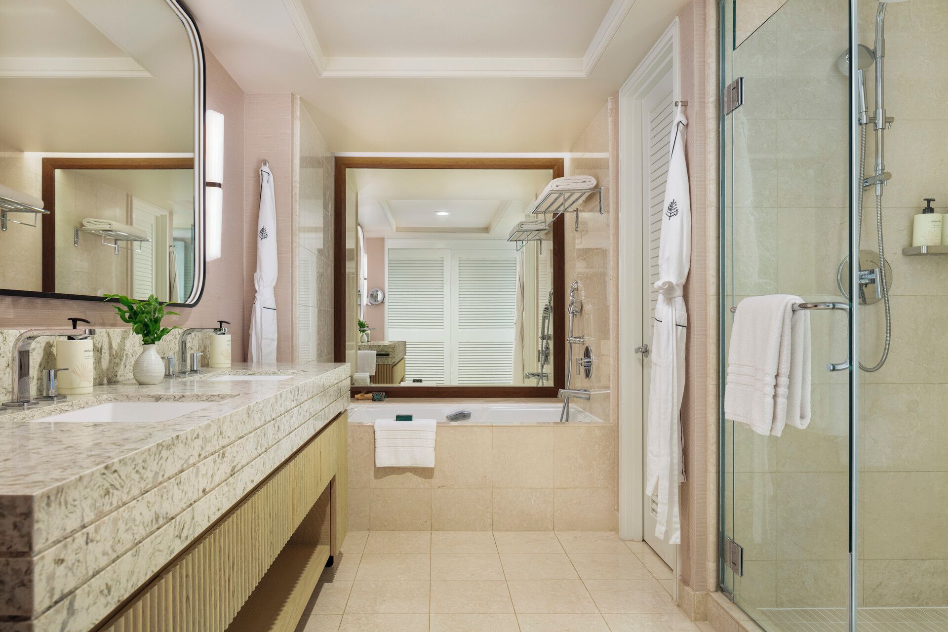 A modern bathroom with a glass-enclosed shower, a large mirror, a marble sink, and a bathtub.