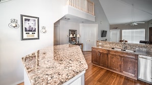 A spacious kitchen with granite countertops, wooden cabinets, and a central island. - Thousand Hills Golf Resort (Branson)