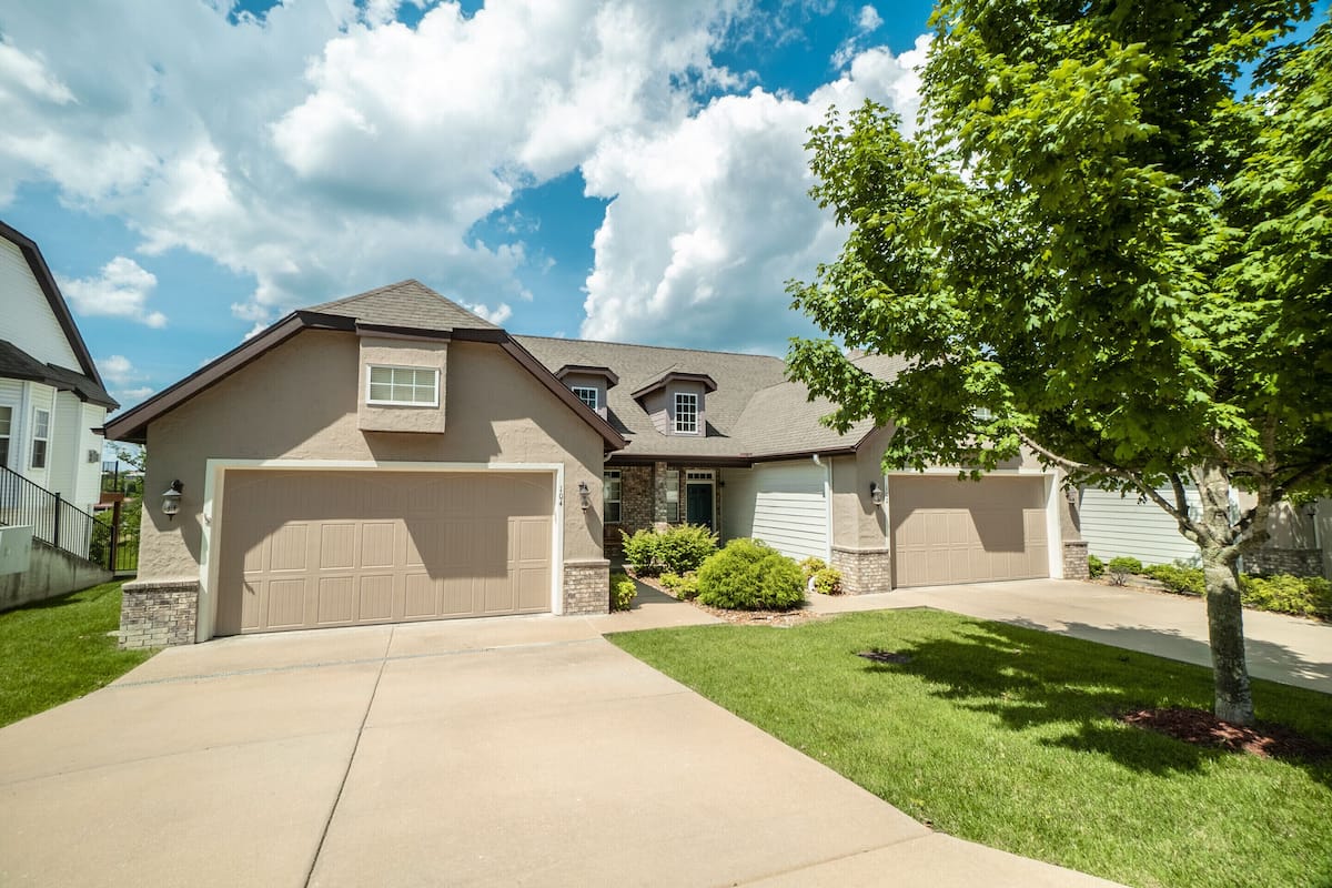A single-story house with a garage, a small front porch, and a well-maintained lawn.