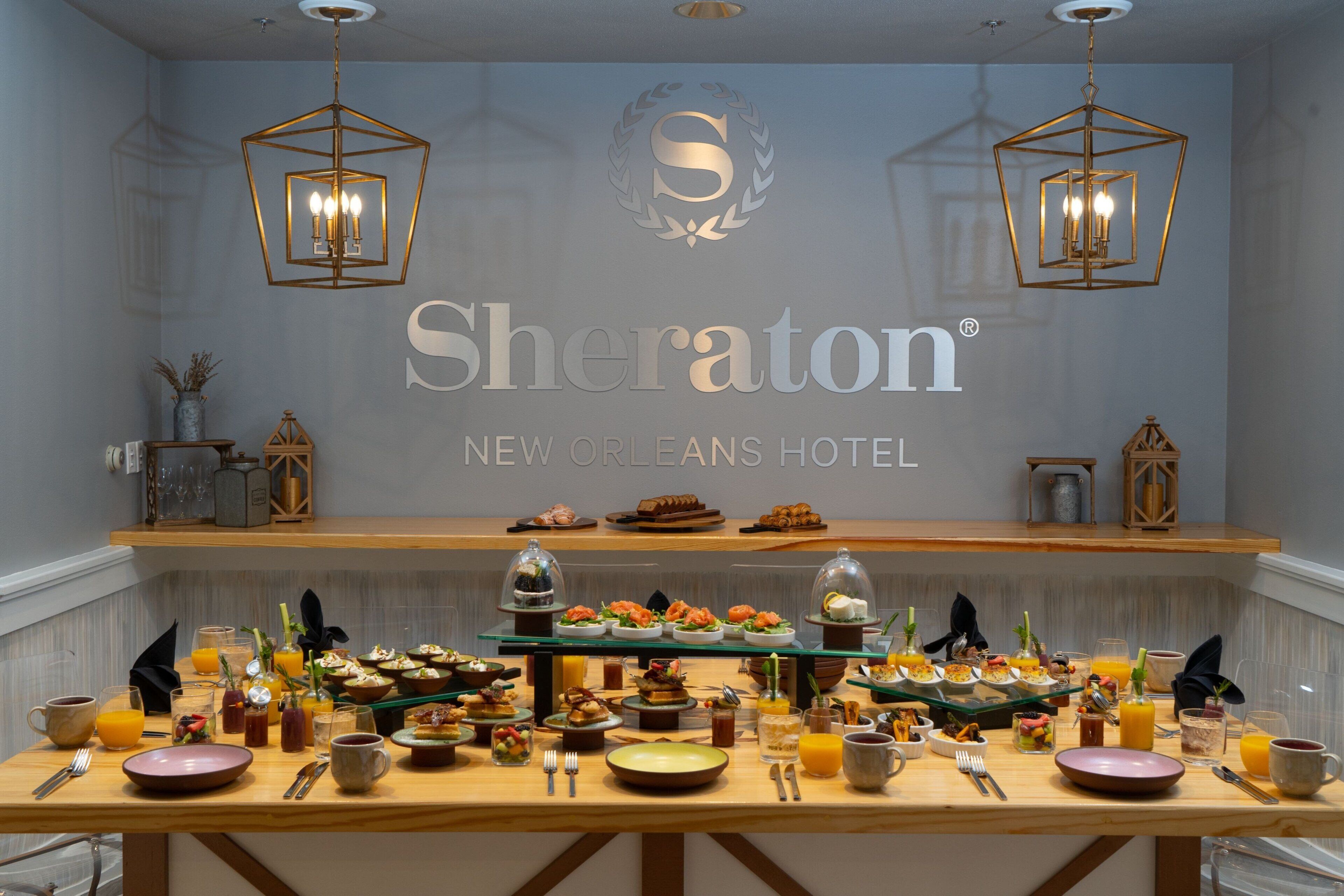 A breakfast buffet at Sheraton New Orleans Hotel with various dishes and beverages.