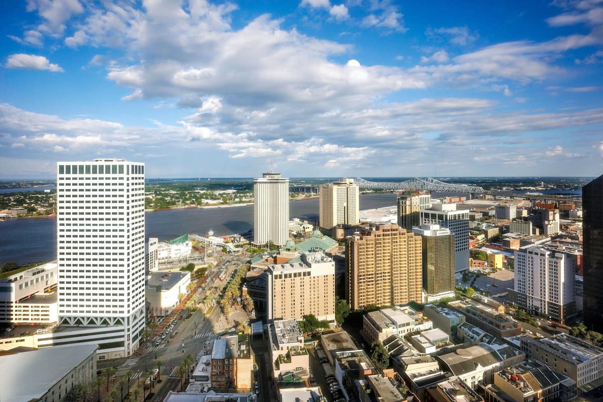 A cityscape with a variety of buildings, including a prominent white skyscraper and several other high-rise structures.