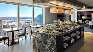 Una cocina moderna con una isla de mármol, ventanas amplias y vistas a la ciudad.