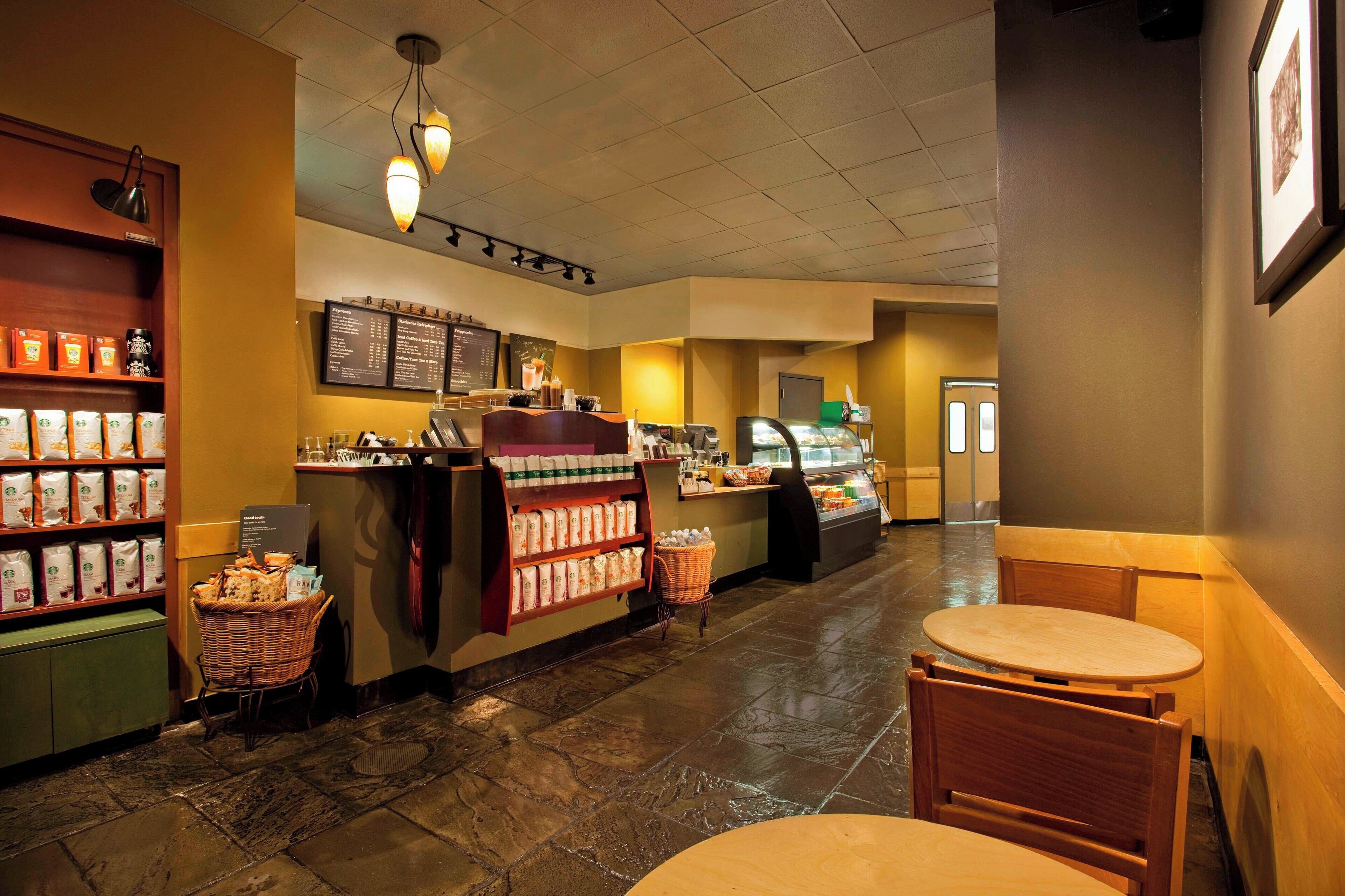 A coffee shop interior with a counter, seating area, and display of coffee beans.
