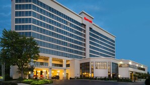 Un hotel moderno con un llamativo letrero de 'Marriott', varios pisos y una entrada bien iluminada.