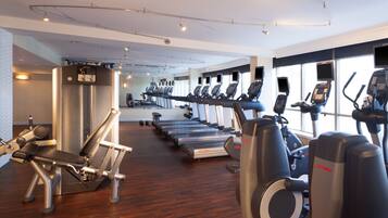 A gym with treadmills, elliptical machines, and weight equipment.
