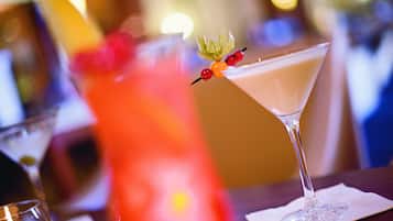 A martini glass with a garnish on a bar counter.
