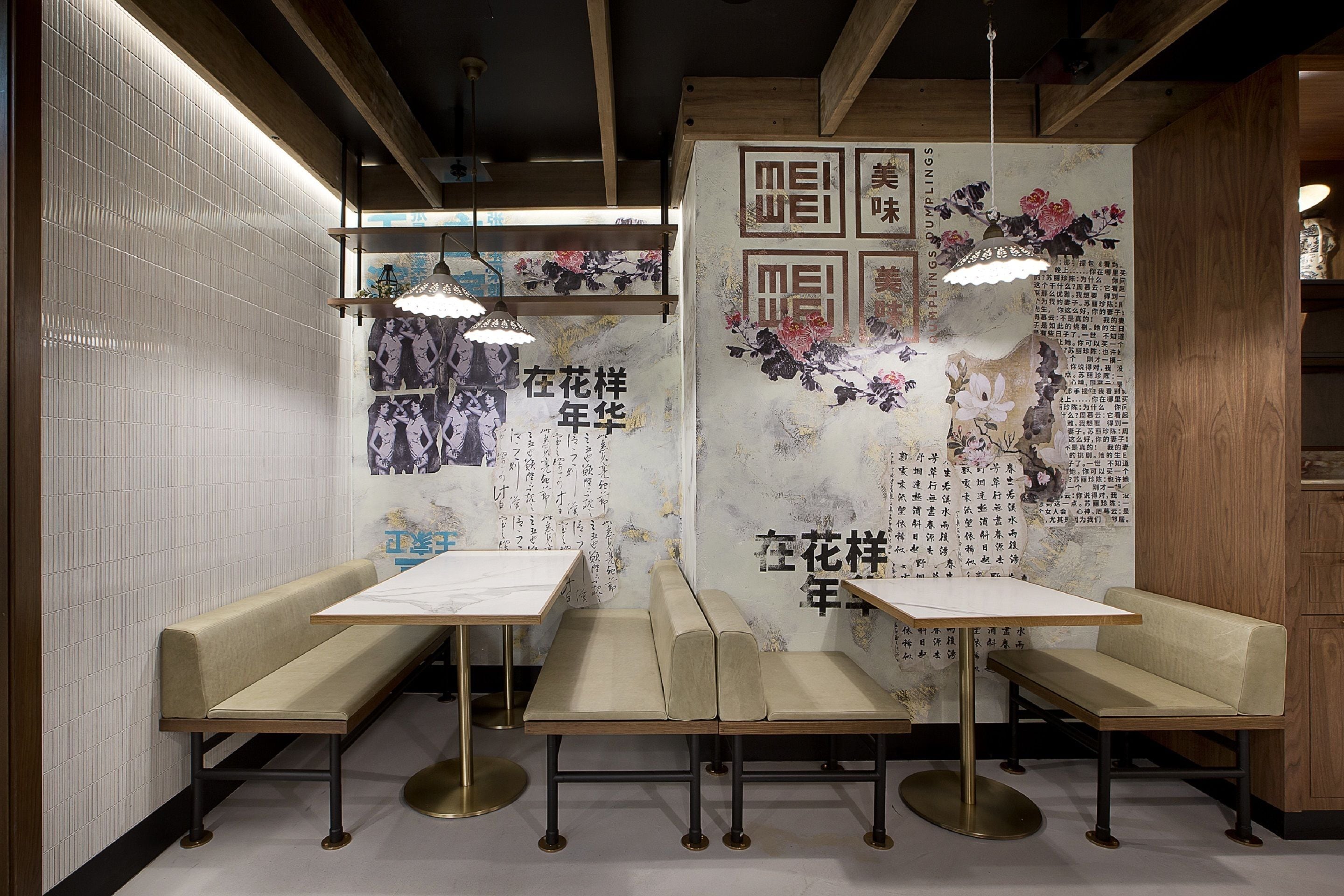 A restaurant interior with wooden beams, tiled walls, and traditional Chinese calligraphy. There are three wooden tables and benches.