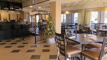 A restaurant interior with a Christmas tree, checkered floor, and bar area with bottles.