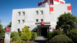 Un bâtiment moderne de l’hôtel ibis, avec une façade plate, de nombreuses fenêtres et une entrée bien définie.