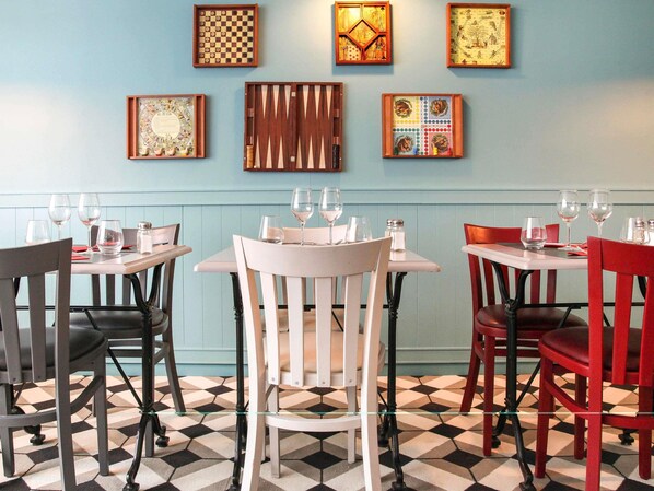 Ein Restaurantinneres mit Tischen, Stühlen und Wandbildern.