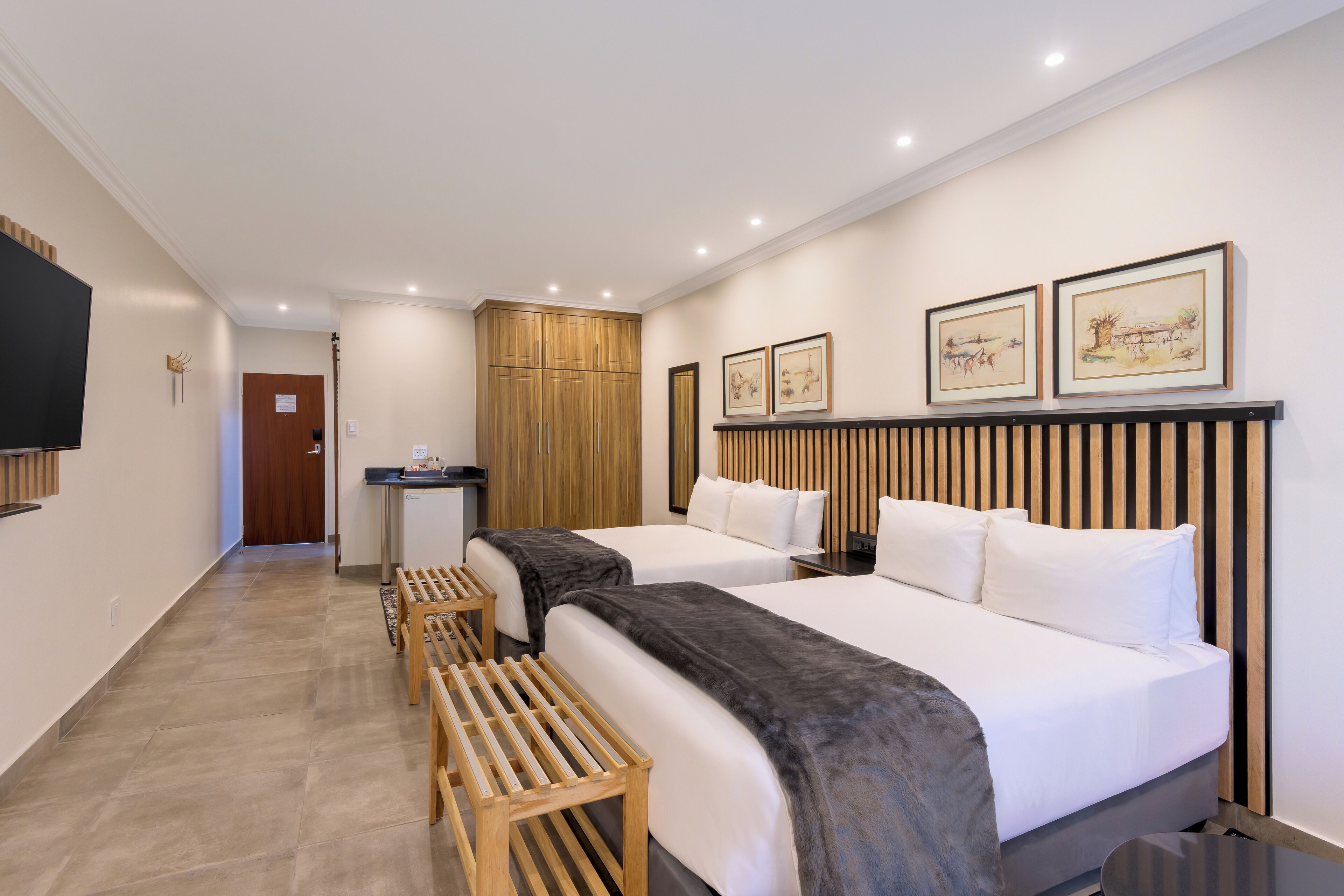 Una habitación de hotel con dos camas, un escritorio y un armario.