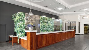 A modern kitchen with a wooden island, pendant lighting, and a decorative backsplash. - Park Hotel Mokopane (Mogalakwena)