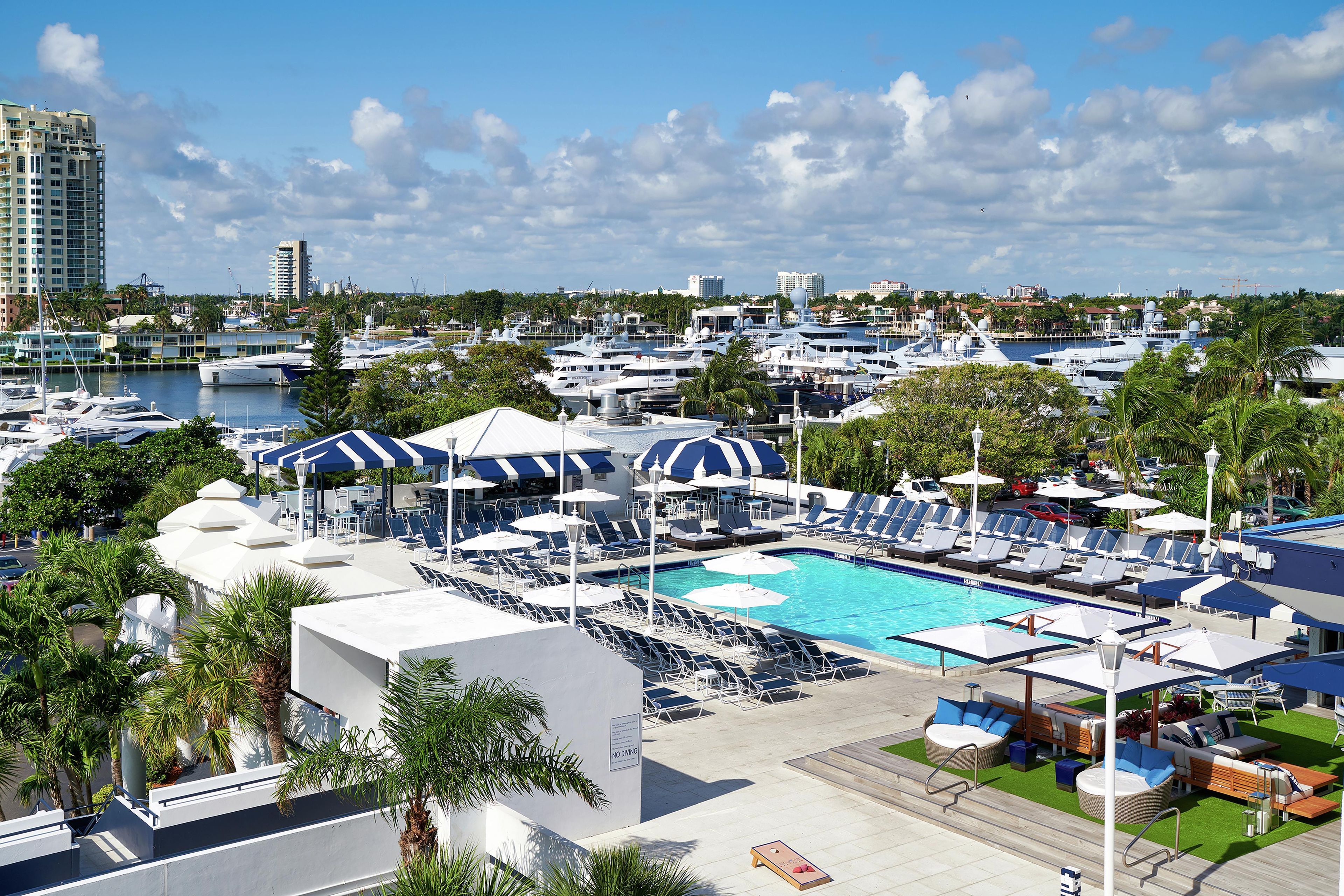 A marina with boats, a swimming pool, and lounge chairs.