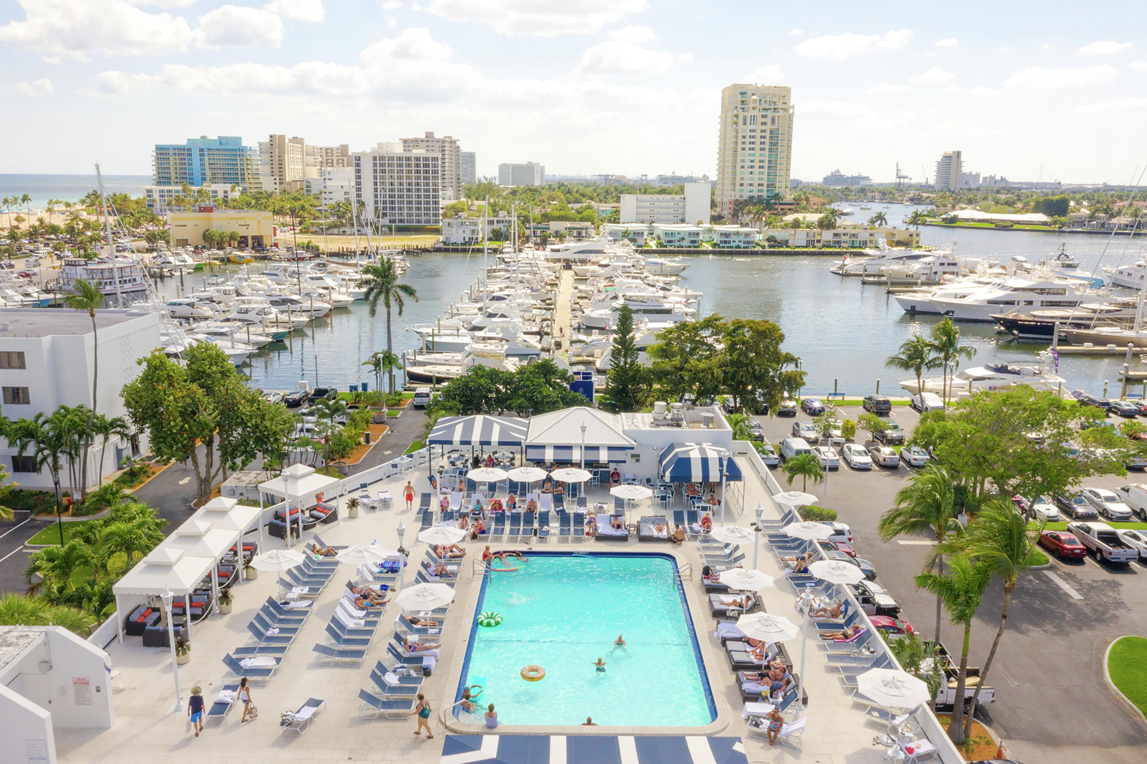 A marina with boats, a swimming pool, and a cityscape in the background.