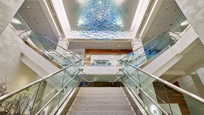 A modern interior with a glass staircase, a decorative ceiling sculpture, and a central atrium. - Bahia Mar Ft. Lauderdale Beach- a DoubleTree by Hilton Hotel (Fort Lauderdale)