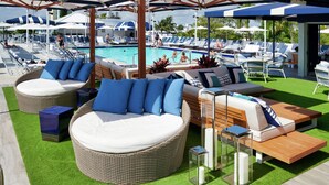 A poolside area with wicker furniture, umbrellas, and lounge chairs. - Bahia Mar Ft. Lauderdale Beach- a DoubleTree by Hilton Hotel (Fort Lauderdale)