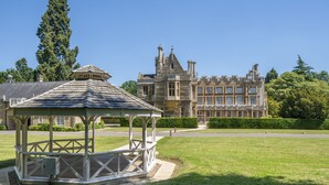 A gazebo in a well-maintained lawn area with a historic building in the background. - Orton Hall Hotel & Spa (Peterborough)