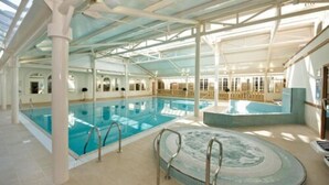 An indoor swimming pool with clear water, a hot tub, and a tiled floor. - Orton Hall Hotel & Spa (Peterborough)