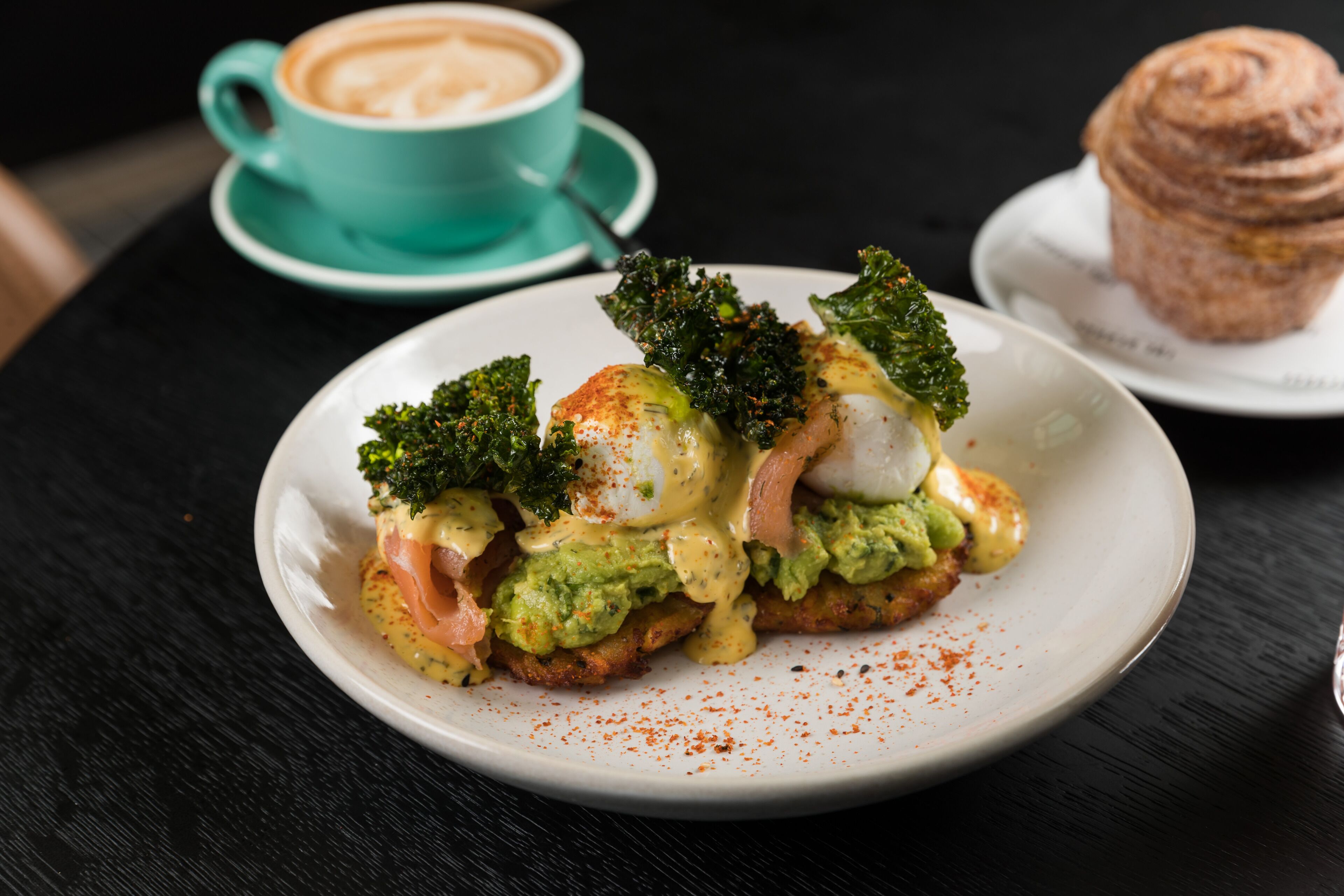A plate of food with a cup of coffee and a muffin on the side.