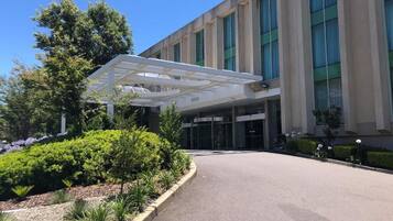 Stunning entrance with a covered walkway, flanked by beautifully maintained gardens.