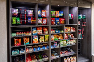 Pasillo con aperitivos en una tienda, con varias marcas de papas fritas, pretzels y otros bocadillos.