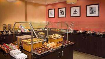 A buffet with various food items and a glass barrier.