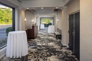 A hotel corridor with a patterned carpet, a reception desk, and tables set up for a meeting. - DoubleTree by Hilton Washington Meadow Lands Casino Area (Washington)