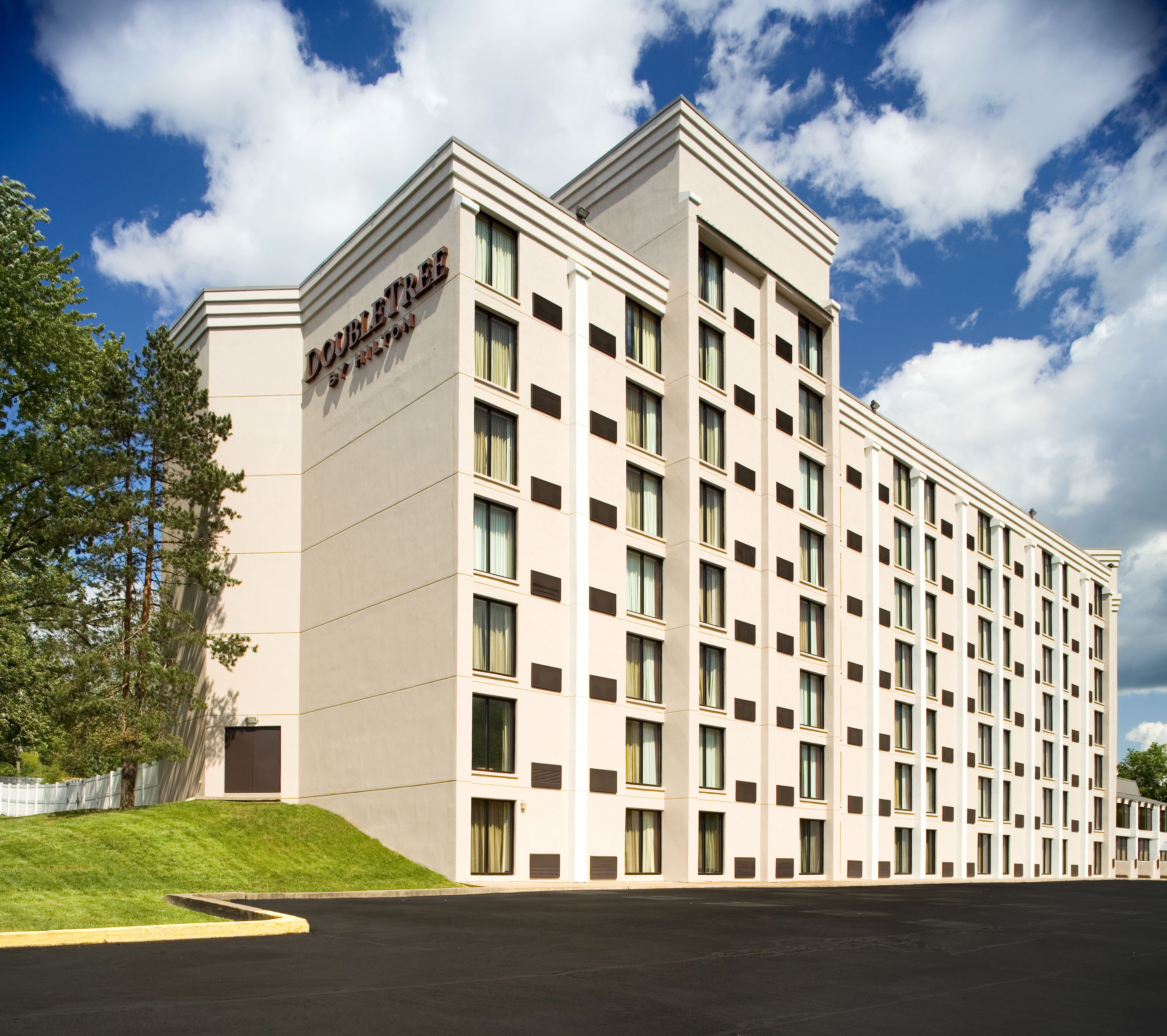Suuri, monikerroksinen hotellirakennus, jossa on symmetrinen julkisivu, lukuisia ikkunoita ja kyltti, jossa lukee: ”DOUBLETREE BY HILTON”.