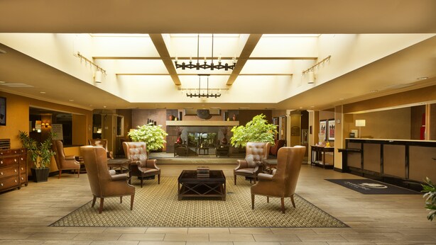 A spacious lobby with leather armchairs, a central coffee table, and a chandelier. - DoubleTree by Hilton Washington Meadow Lands Casino Area (Washington)