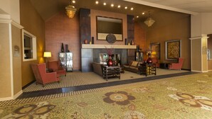 A spacious lobby with a large patterned carpet, a fireplace, seating area, and a large mirror above the fireplace. - DoubleTree by Hilton Washington Meadow Lands Casino Area (Washington)