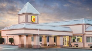 A hotel with a prominent Super 8 sign, a central tower, and a covered entrance area.
