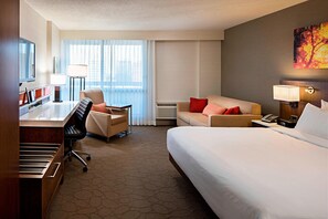 Relax in a stylish room with a large bed, desk, sofa, and television.