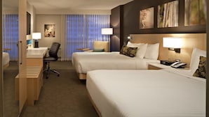 A hotel room with two beds, a desk, a chair, and a small table. - Delta Hotels by Marriott Winnipeg (Winnipeg)