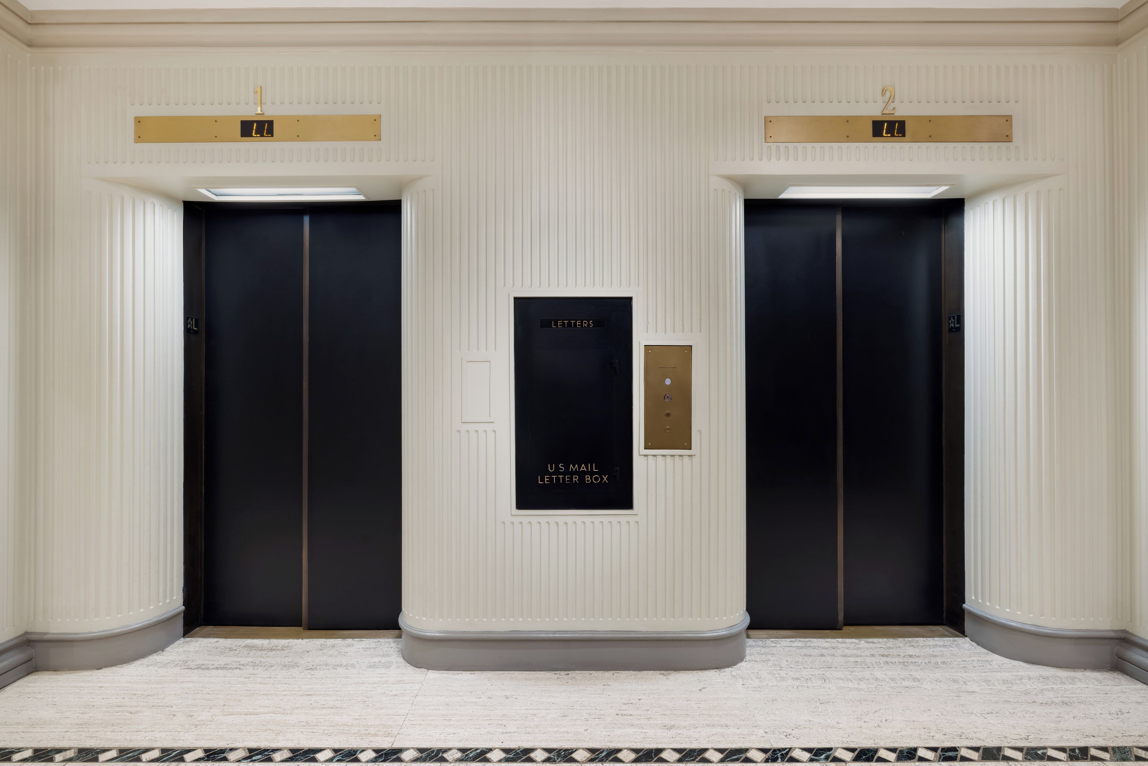 A hallway with two elevators, each marked with a number and a digital display.