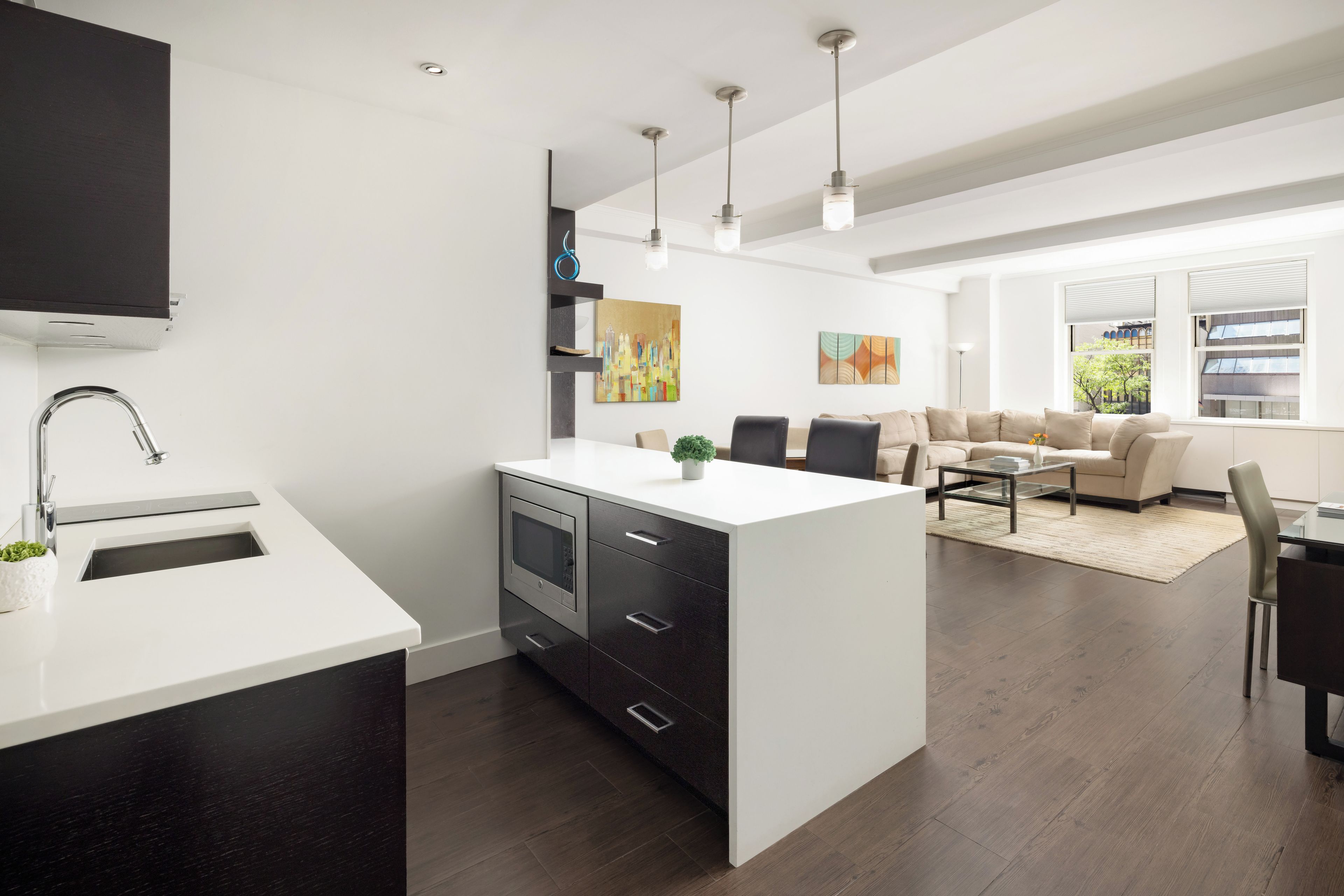 Una cucina moderna con isola centrale, elettrodomestici integrati e illuminazione a sospensione.