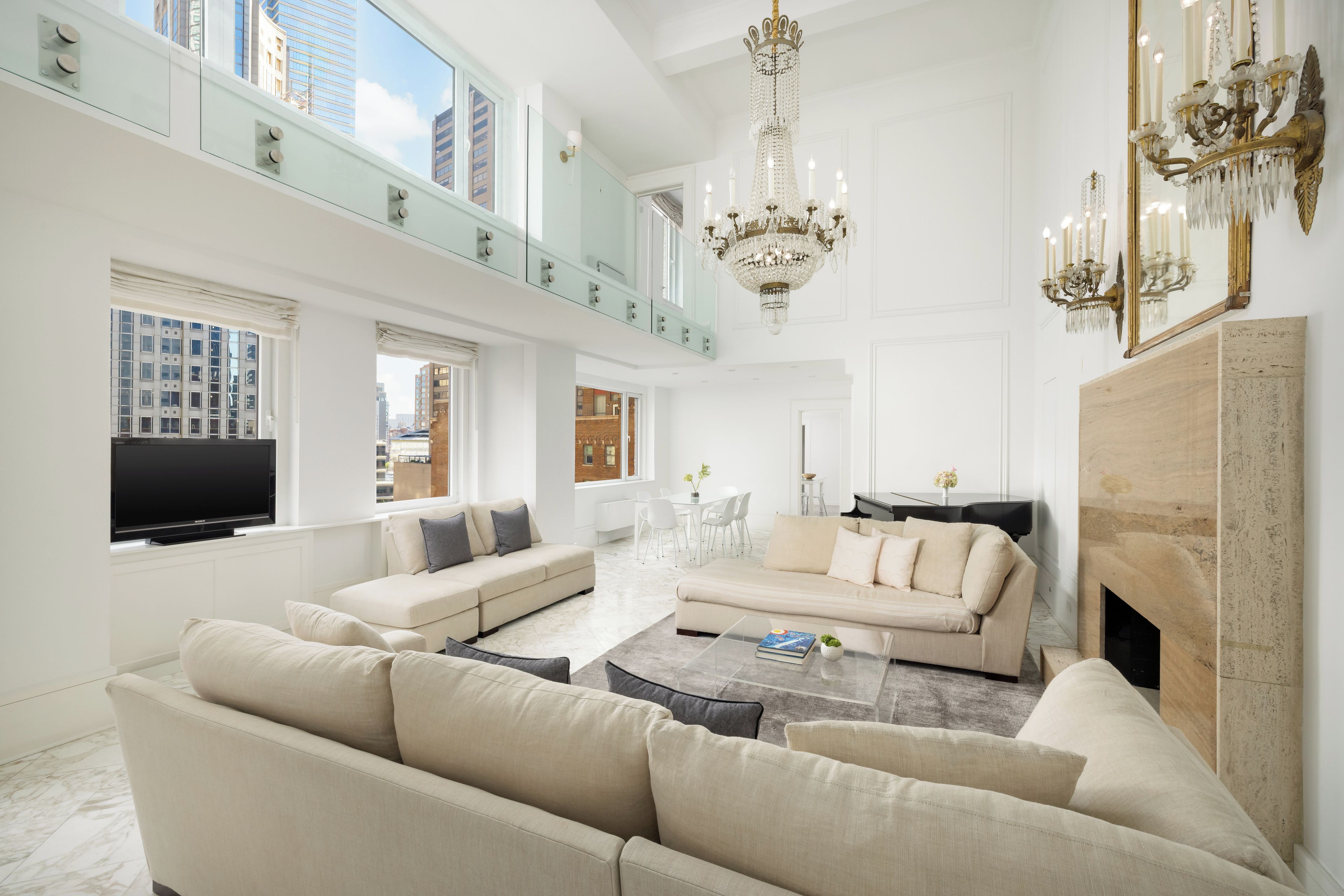 A spacious living room with a large sofa set, a flat-screen TV, and a fireplace.
