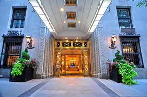A grand entrance with a central doorway, flanked by ornate columns and decorative lighting. - The Lombardy Hotel (New York)