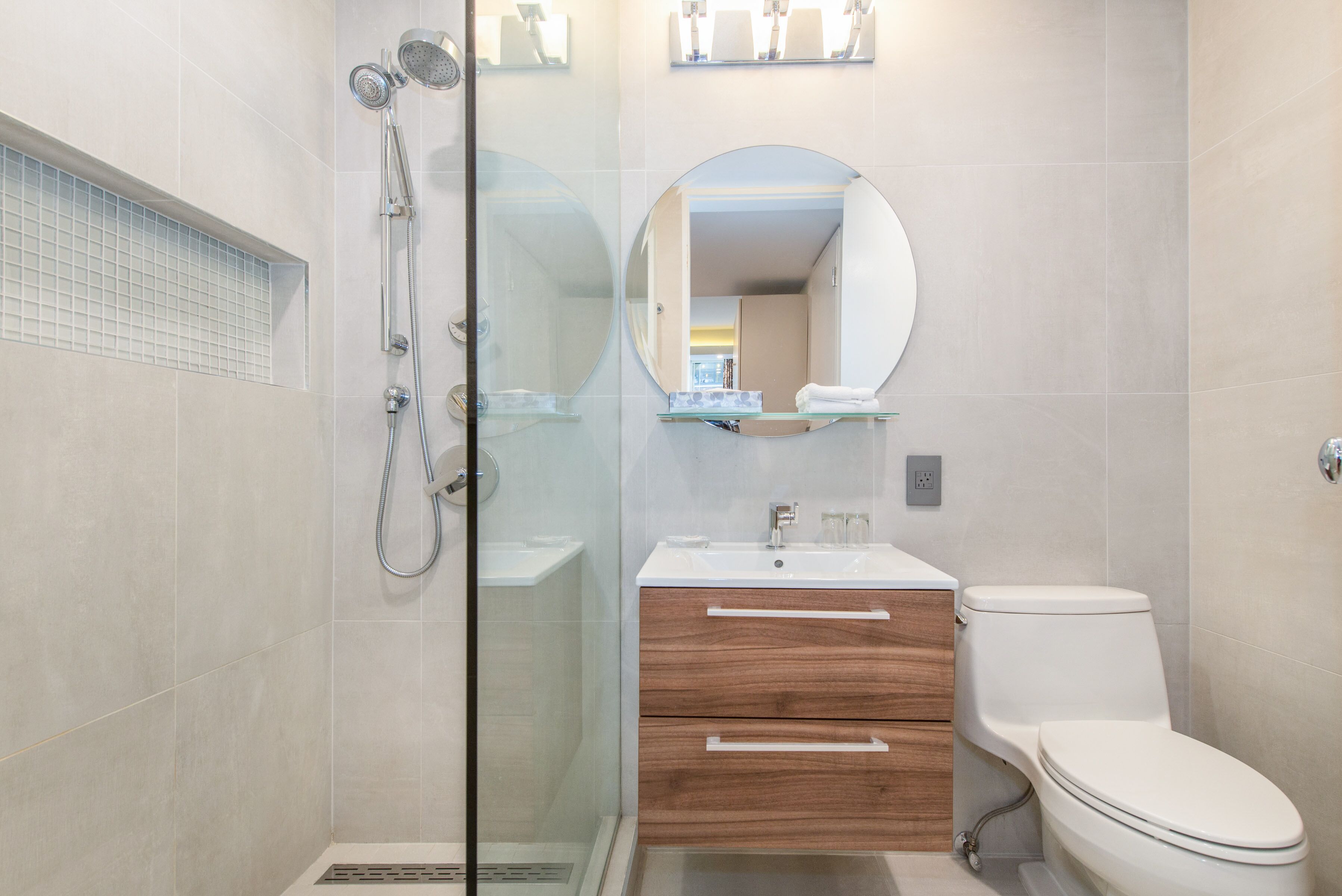 Une salle de bain moderne avec une douche à parois de verre, un meuble-lavabo en bois et des toilettes.