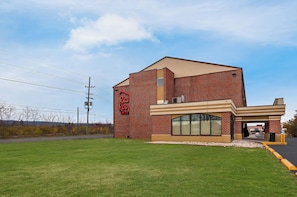 A brick building with a large arched window and a sign that reads 'Red Root Inn.' - Red Roof Inn Martinsburg (Martinsburg)
